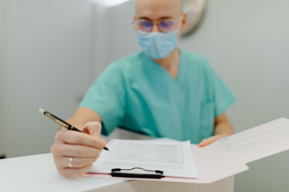 Physician writing notes representing DPC membership included coverage